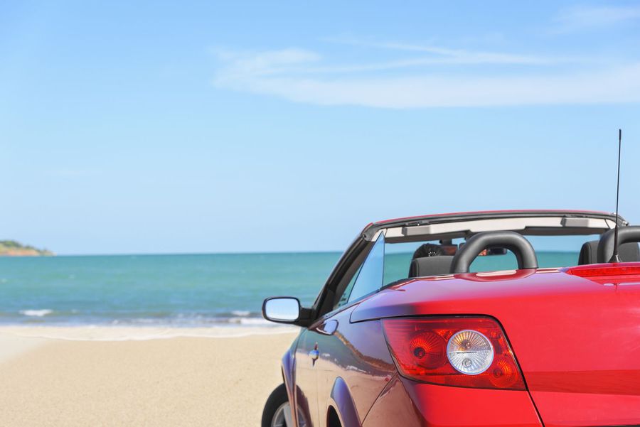 Summer car trip vacation . Summer car trip vacation . Woman in red car at background of sea water. Travel ,freedom and holidays concept.